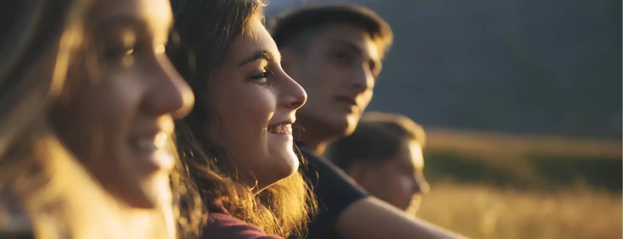 jeunes souriants profitant du soleil couchant en exterieur m